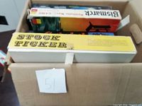 Top view of vintage Stock Ticker game box and other games in the cardboard box