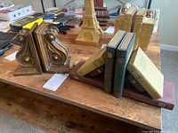 Bookends showing arrangement with books and details of scroll design in metallic finish