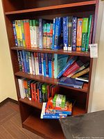 Photo of bookshelf with three shelves of varied educational textbooks including statistics, calculus, and test prep books.