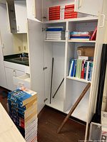 Photos showing white cabinet and shelving stocked with several SAT and ACT prep books plus foreign language books, with additional items like sticks leaning inside the cabinet.