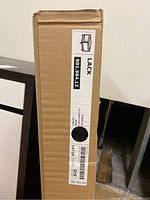 Side view of the box showing label with model number 901.984.12 and 'LACK' series name, dimensions 55x55 cm, weight 10 kg.