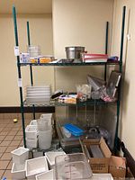 Full view of NSF green metal shelving unit with various food service containers and kitchen items on shelves.