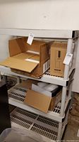 Close-up of shelving unit corner with partial view of cardboard boxes illustrating shelving dimensions and condition.