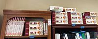 Bookshelves with multiple Barron's IELTS Practice Exams books and IELTS Superpack boxed sets arranged