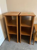 Two wooden shelf units side-by-side showing front view with three shelves each and flat tops.