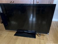 Front view of Sony 42 inch LCD TV on floor with black bezel and stand.