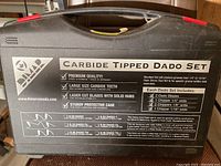 Exterior of black plastic carrying case labeled ‘Carbide Tipped Dado Set’