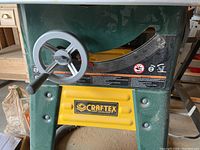Front view showing green/yellow frame, bevel adjustment wheel and Craftex logo