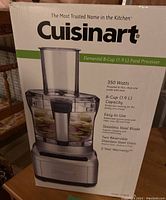 Photo of the original product box showing the front with the image of the Cuisinart Elemental 8-Cup Food Processor and key features such as 350 watts, 8-cup capacity, stainless steel blade, two reversible stainless steel discs, and 2-year warranty.