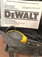 Instruction manual for DeWalt random orbit palm sanders (models D26450, D26451, D26453) and yellow/black sander handle and cord inside black zippered case.
