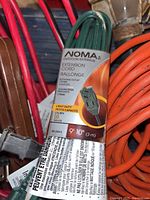 Close-up of green NOMA extension cord packaging showing length and features.