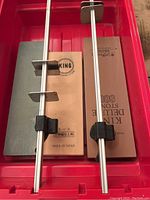 Two sharpening stones with metal holders inside a red container, showing King Deluxe Stone 800 and King S-3 stone, both made in Japan.