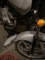 Front wheel and fender of 1982 Suzuki GS400E motorcycle, showing silver fender and five-spoke alloy wheel