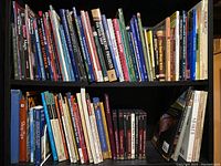 Two shelves with assorted woodworking books and DVDs