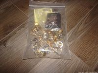 Photo of all rings and a small bag containing additional pieces on floor.