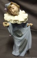Front view showing porcelain Pierrot figure in pale blue clothing and large cream ruffled collar