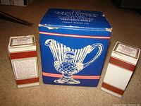 Box and two Avon 1876 Cape Cod salt and pepper shakers in original packaging with text describing product and usage.