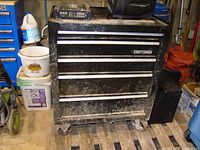 Front view of the Craftsman 5-drawer steel rolling tool cabinet showing dirt and wear on the drawers and casing.