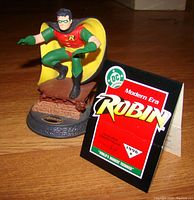Photo of Robin resin figurine crouching on brick base with certificate and original packaging materials