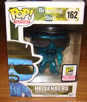 Front view of Funko Pop box showing the translucent blue Heisenberg figure with black sunglasses and hat, sticker for 2015 Comic Con Limited Edition visible on front.