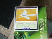 Box front showing fan image and specifications including 52 inch blade size, white finish, and reversible wood blades.