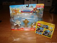 Skylanders SuperChargers Sky Racing Action Pack featuring Astroblast and Sun Runner action figures and a Sky Trophy in original packaging on a hardwood floor.