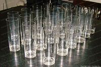 Set of 22 slim tall high ball cocktail glasses arranged on table showing quantity and uniformity.