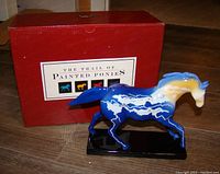 Lightning Bolt Colt figurine with original red box, standing on black base, showing lightning storm design over blue and yellow glaze.