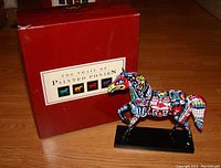 Photo of the colorful resin pony figurine in front of original red box labeled The Trail of Painted Ponies.