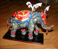 Circus Star elephant sculpture on black base showing painted details and feather headpiece.