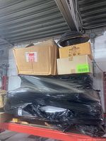 Wide view of skid showing packaged folding chairs, cardboard boxes and cable spool