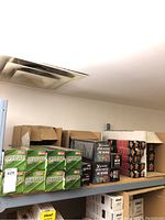 Shelf view showing stacked green boxes of Lightspeed GameBulb 630W bulbs alongside other grow light boxes