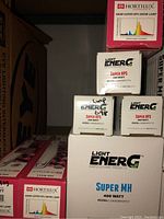 Shelf of grow lamp boxes including Hortilux 600W Super HPS, Light EnerG Super HPS 600W and Light EnerG Super MH 400W