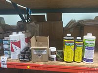 Overview of shelf showing assorted rooting hormone bottles, powder tubs, boxes and disinfectant