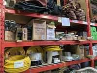 Middle warehouse shelf showing coiled cables, boxed stands, hangers, bulbs and substrate
