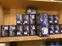 Full shelf view of various Grozone controller boxes arranged on a wooden shelf