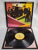 Photo of the vinyl record partially pulled from its sleeve, showing label and part of album cover.