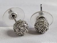 Front and top angle view of the vintage sterling silver spherical filigree stud earrings with clear plastic backs, showing detailed weaving pattern and shine.