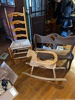 Overall view of the rush seat chair, child's rocking horse, and child's bench together in room setting on hardwood floor.