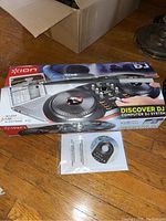 Ion Discover DJ System box with software CD and manual displayed on floor.
