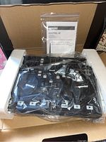 Photo showing two Gemini CNTRL-2 DJ controllers wrapped in plastic inside original box with foam for protection, including manual and USB cable.
