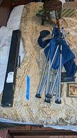 Pool cue, black carrying case, and folded camp chair on bedspread, showing full items in lot.