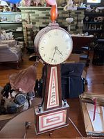 Full view of the vintage Seth Thomas wall clock showing the entire wooden structure with inlaid decorative panels and round clock face.