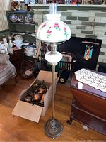 Full view of the vintage floor lamp with floral hurricane style glass shade and brass-tone stand and base.