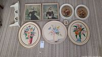 All eight pieces of floral and women-themed wall art along with the white wood wall shelf arranged on carpet for clear view.