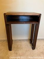 Front view of a rectangular wooden accent table showing the open shelf and sturdy legs.