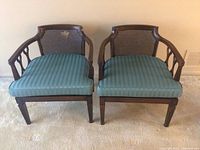 Front view of the two matching chairs showing blue striped cushions and woven backs
