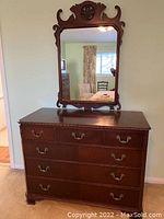Front view of dresser with mirror against wall shows overall condition and design