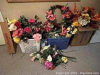 Wide shot of two bins and loose faux flowers in front, showing a variety of artificial flowers in different colors and types.