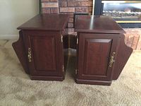 Photo showing both wooden side cabinets with front doors and attached side magazine racks, displaying overall design and condition.